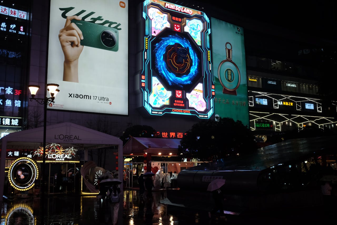 who-we-are Vibrant urban cityscape at night showcasing illuminated neon billboards and bustling street life.